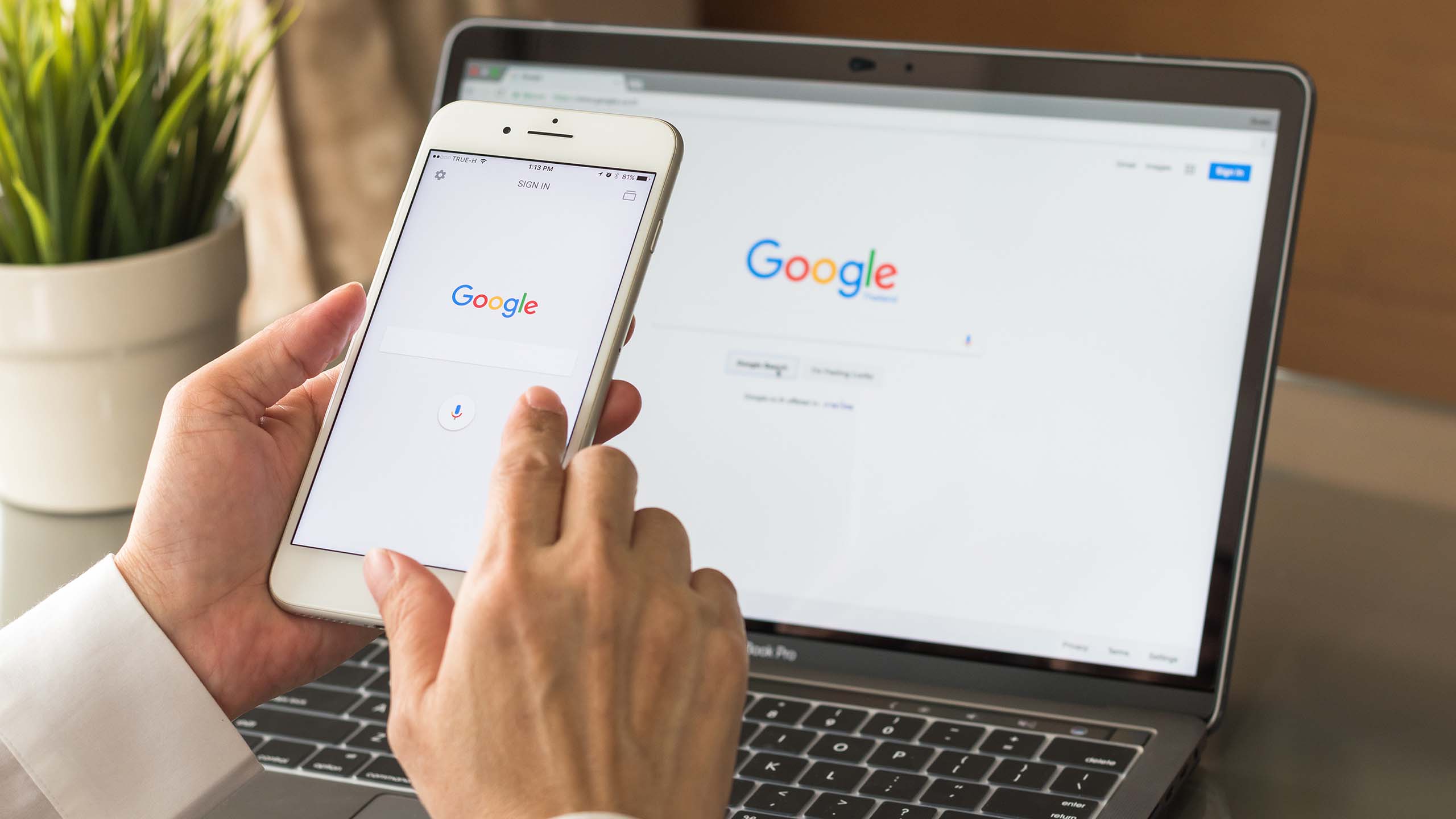 Sökmotorn Googles förstasida för sökning på en mobiltelefon och på en laptop